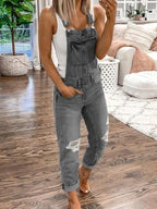 Grey bib overalls with distressed knees and rolled hems.