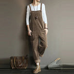 Khaki corduroy dungarees with broad straps, front pockets and turned-up hems.