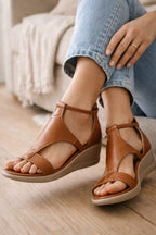 Brown open-toe wedge sandals with shaped uppers and ankle straps.