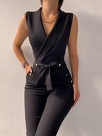 Black V-neck Sledo jumpsuit with a tied waist and button details.