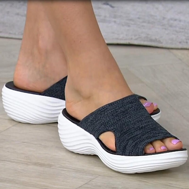 Black sandals shown from the front with curved side cutouts.