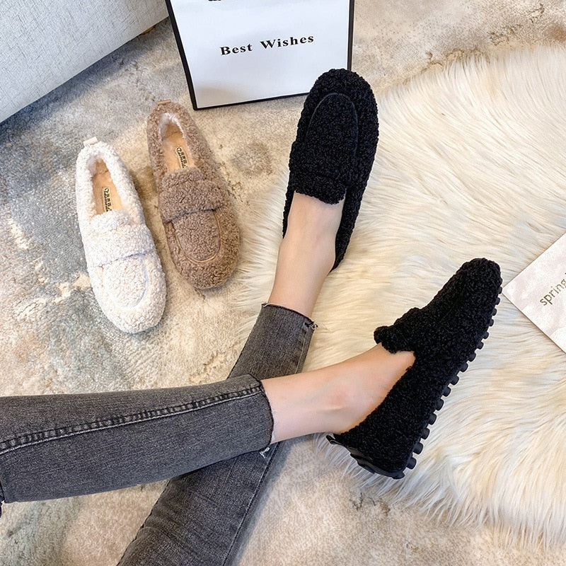 Black slippers worn beside cream and khaki pairs.