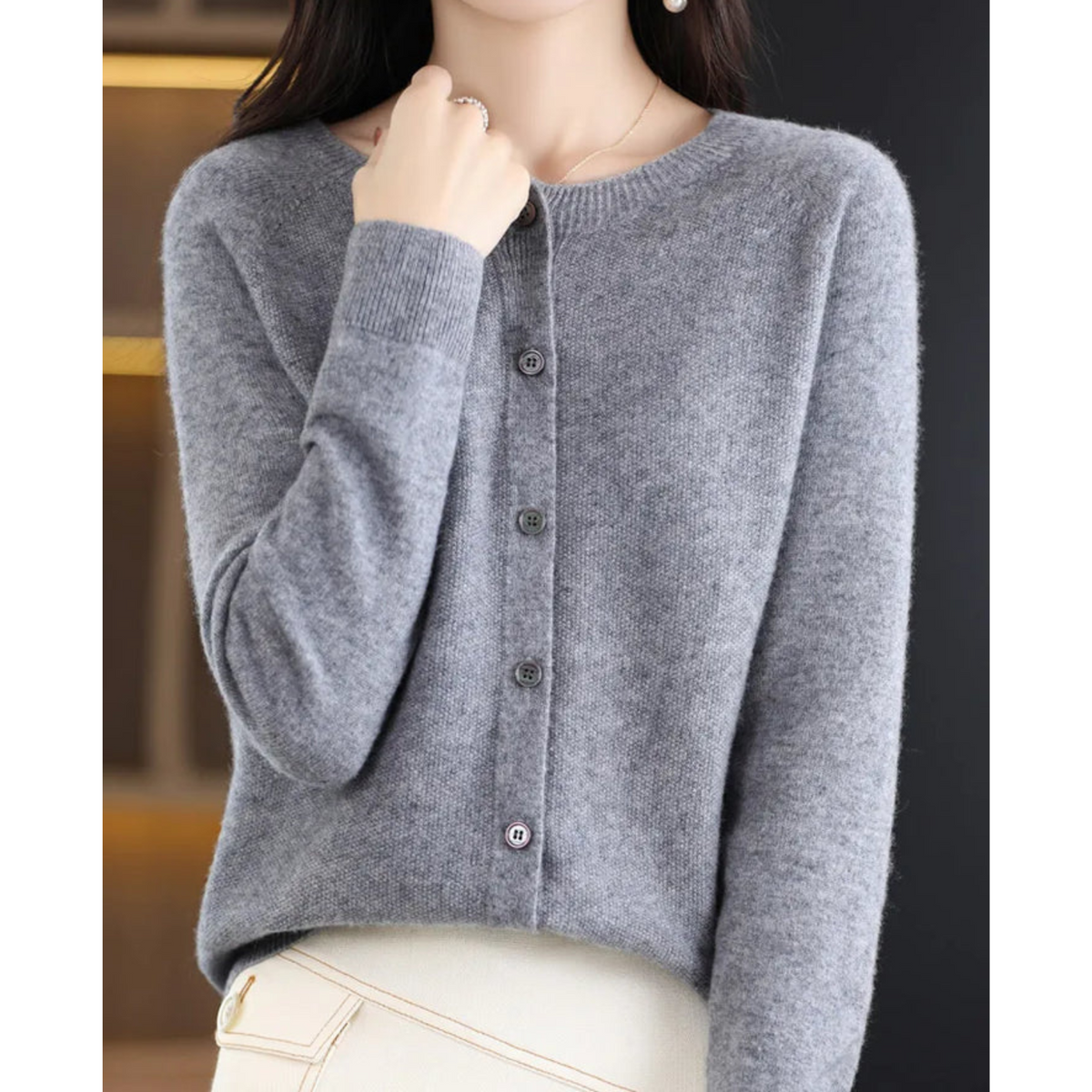 Grey cardigan with a round neckline, small buttons and ribbed cuffs.