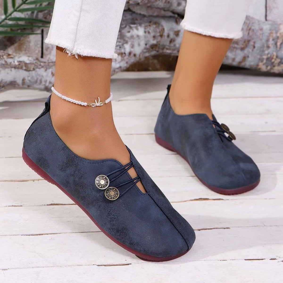 Navy blue slip-on shoes showing the front cut-out and decorative cords.