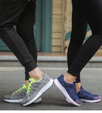 Grey and green trainers beside blue and pink trainers.