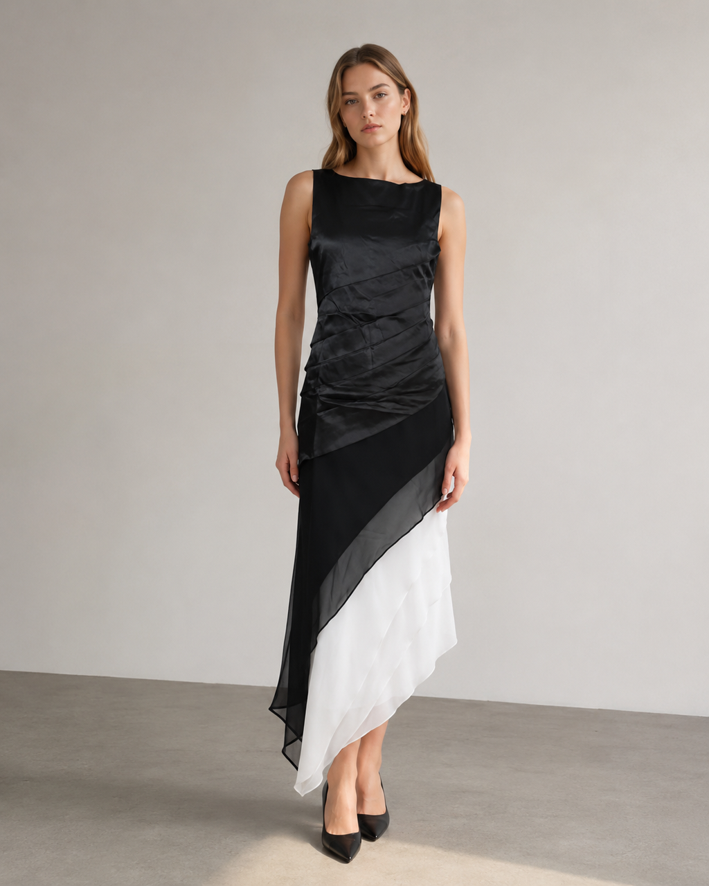 Front view of a sleeveless layered dress with a black bodice and diagonal black, grey and white skirt.