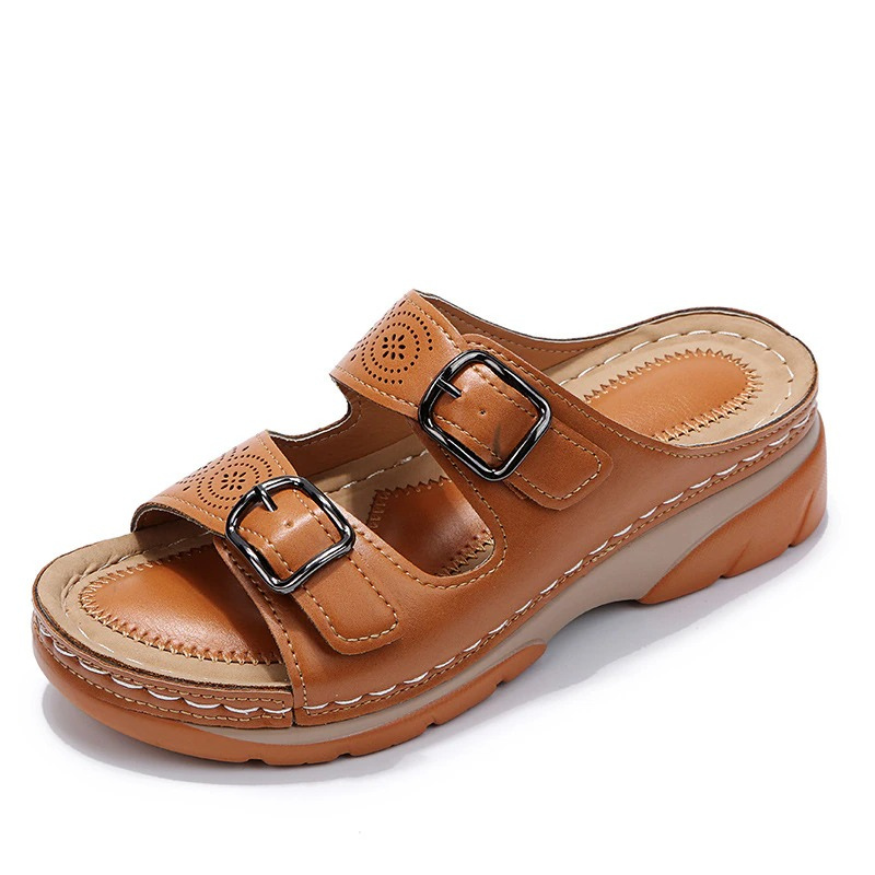 Brown slide sandal with two buckle straps and circular cutout details.