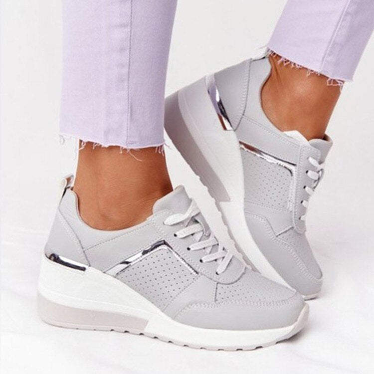 Grey lace-up trainers with a chunky white sole.