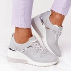 Grey lace-up trainers with a chunky white sole.