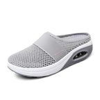 Light grey open-back mesh shoe with a wide front band.