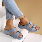 Light blue perforated slide sandals worn with cropped jeans.