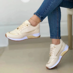 Beige lace-up trainers with gold-coloured trim and contrasting white sole sections.
