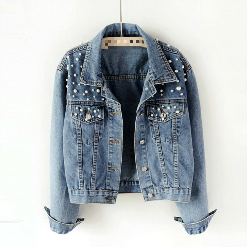 Blue beaded denim jacket hanging with the cuffs turned up.