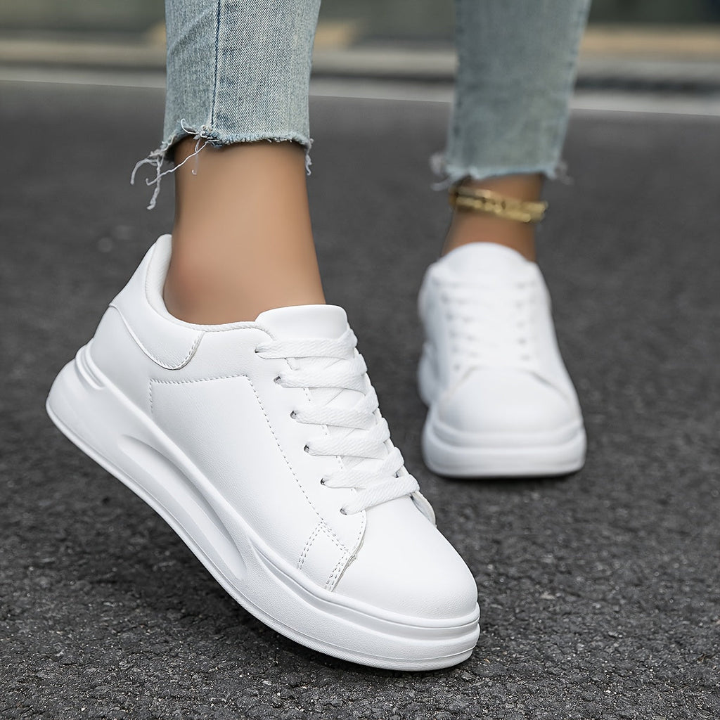 Front view of white trainers with rounded toe caps and flat laces.
