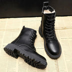 Black boots with one laid on its side to show the deep outsole tread and the other upright.