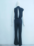Back of a dark jumpsuit on a mannequin, showing a long opening down the upper back.