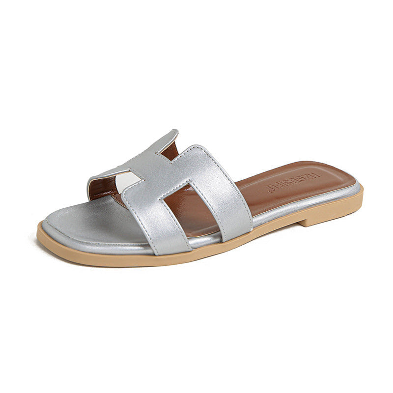 Silver cut-out slide sandal with a pale sole and brown heel footbed.