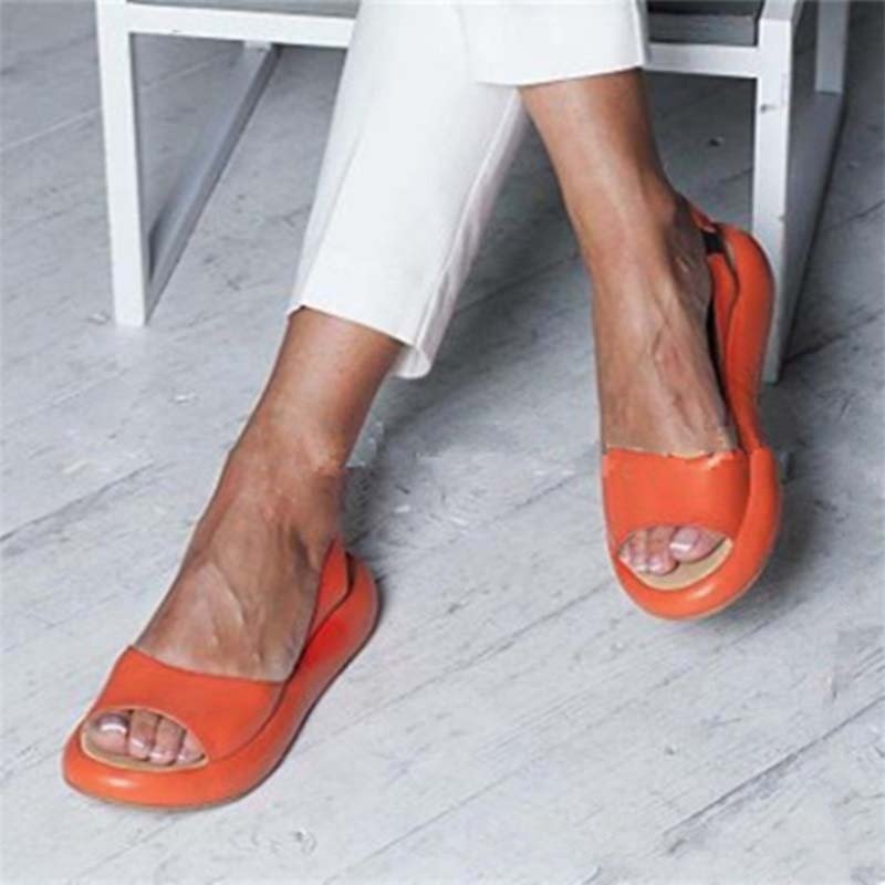 Orange Keliso sandals with broad front straps and open toes.
