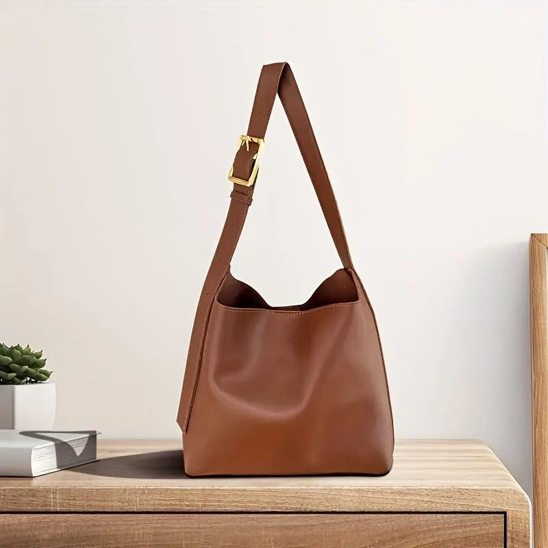 Brown shoulder bag with a wide strap and gold-coloured buckle.