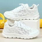 Two white floral trainers displayed on blocks, showing outer and inner side panels.