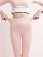 Pink leggings with the waistband held out to show its stretch.