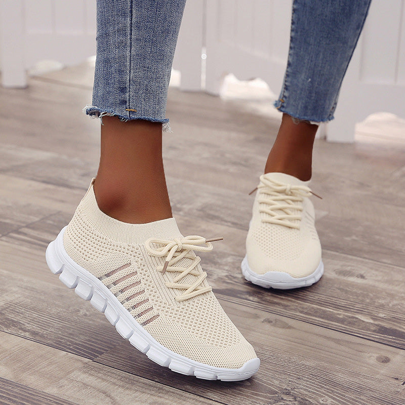 Beige textured trainers worn with cropped jeans.