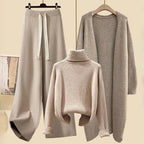 Beige jumper, drawstring trousers and matching long jacket arranged on hangers.