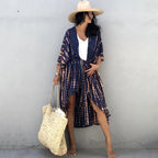 Navy printed cover-up tied at the waist over a white top and denim shorts.