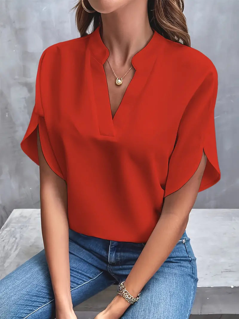 Red split-neck blouse worn with blue jeans.