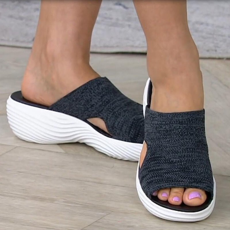 Black open-toe sandals with textured stretch uppers.