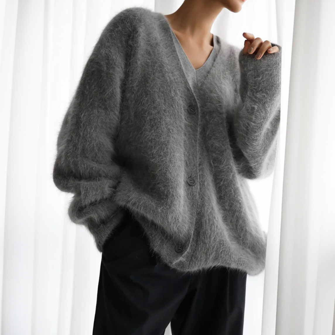 Dark grey V-neck cardigan with buttons and a fuzzy surface.