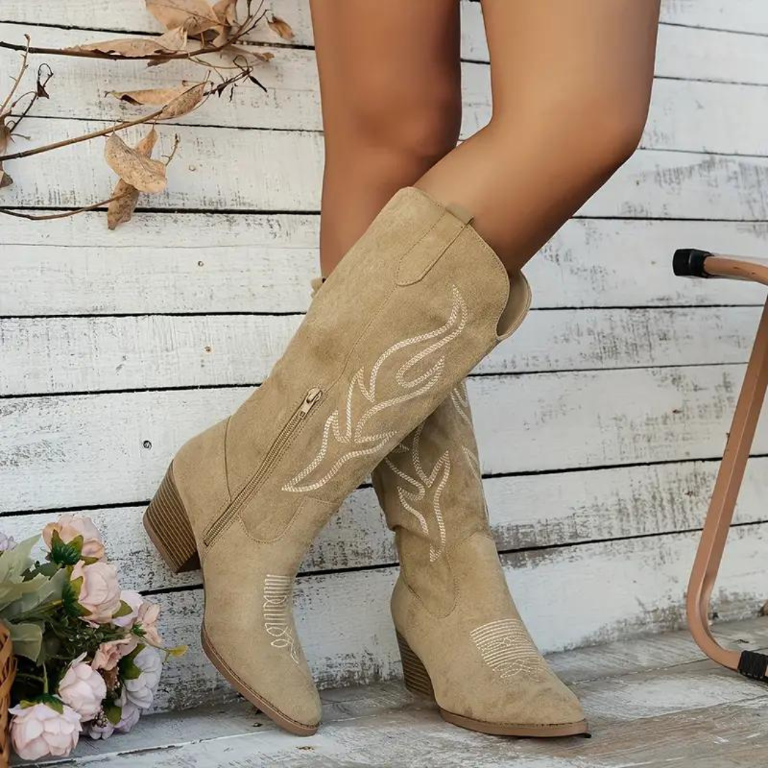 Sand-coloured boots with decorative stitching and layered-looking heel edges.