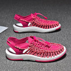 Pink cord sandals with white soles on a dark surface.