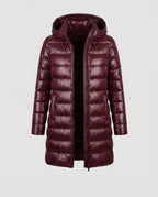 Burgundy long quilted jacket with a hood and central zip.