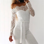 White off-shoulder jumpsuit with sheer lace sleeves and a tied waist.
