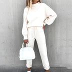 White two-piece lounge set with a high neck and drawstring trousers.
