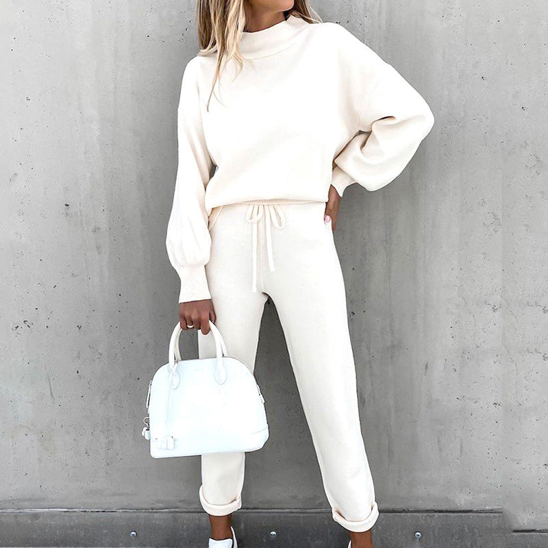 White two-piece lounge set with a high neck and drawstring trousers.