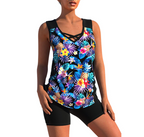 Floral black tankini with crossed neckline straps and black swim shorts.