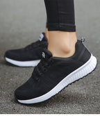 Black trainers with mesh-textured uppers and white soles.