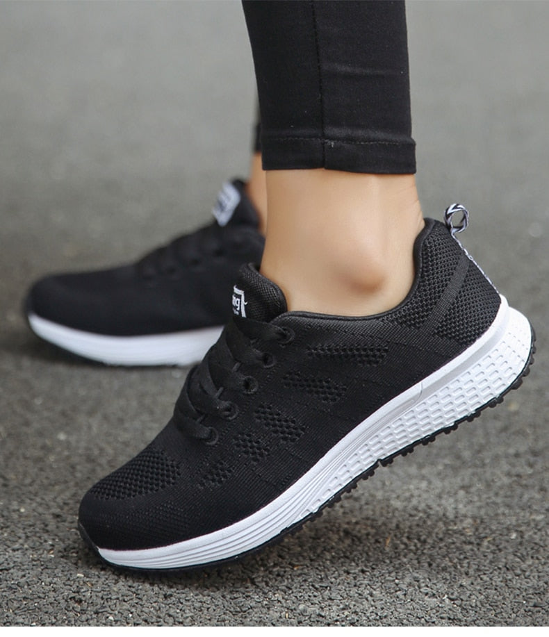 Black trainers with mesh-textured uppers and white soles.