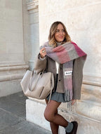 Woman wearing a checked scarf with a taupe tote over her shoulder.