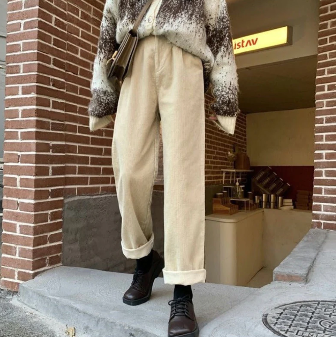Beige trousers with turned-up hems, worn outdoors.