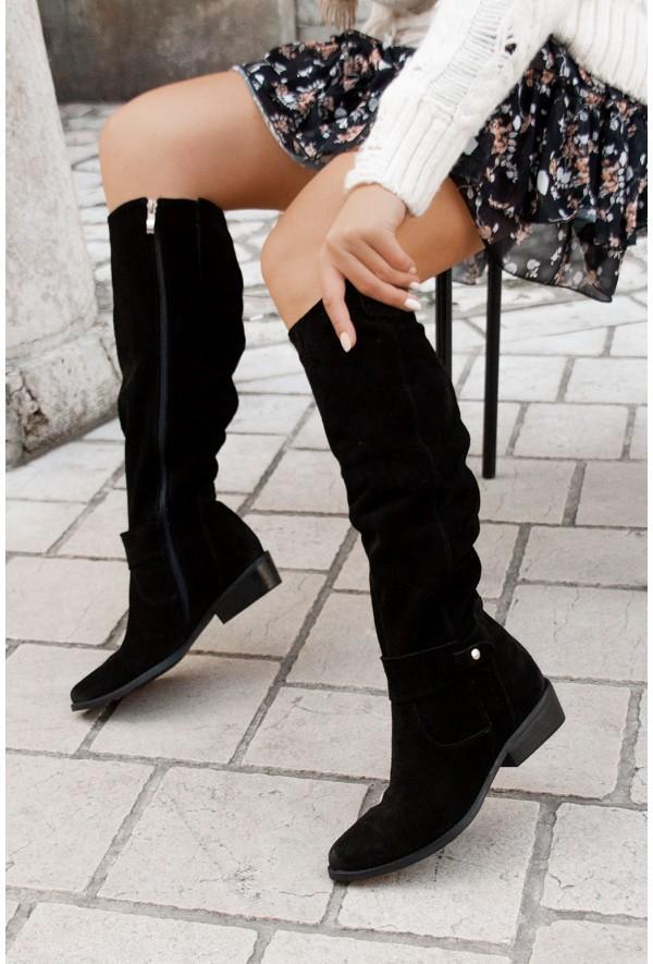 Black boots shown with a patterned skirt, exposing a side zip.