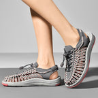 Grey and pink cord sandals worn in front and side views.