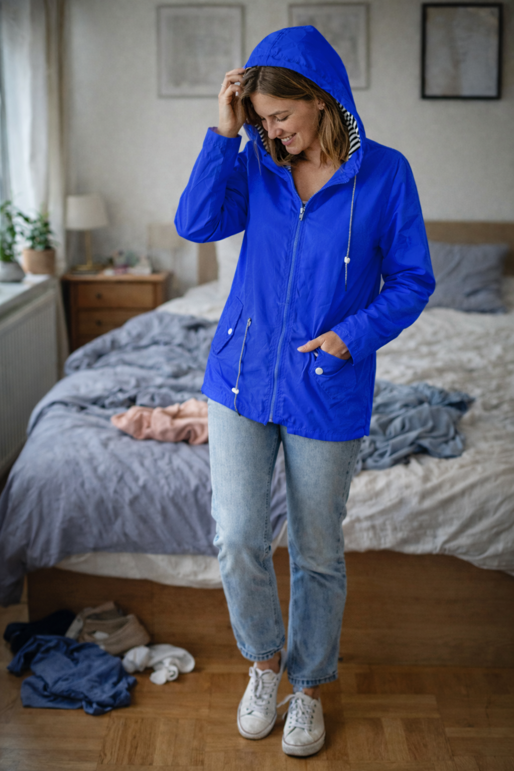 Blue parka with a striped hood lining and waist cords.