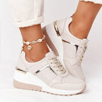 Beige lace-up trainers with a raised white sole.