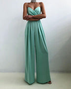 Turquoise jumpsuit with a folded neckline and slim straps.