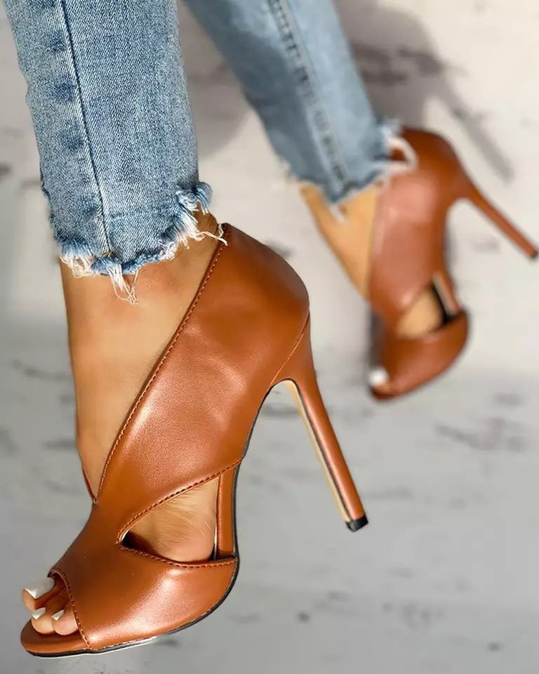 Brown high-heeled shoe showing its closed back and side cutout.