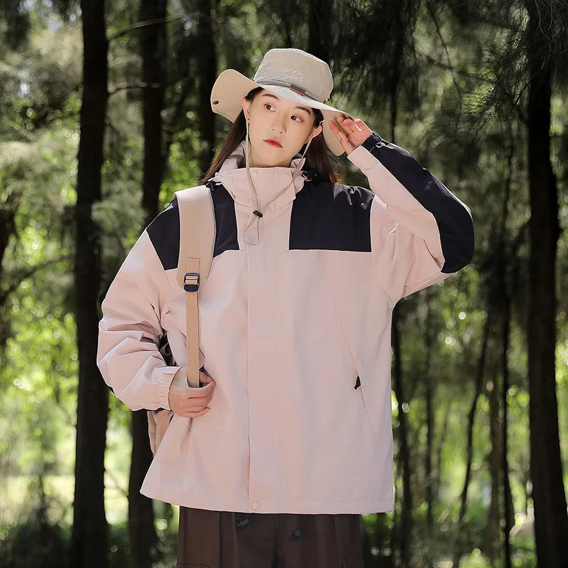 Pink and black jacket worn with a hat and shoulder bag.