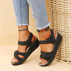 Black wedge sandals with cutout front straps and open toes.